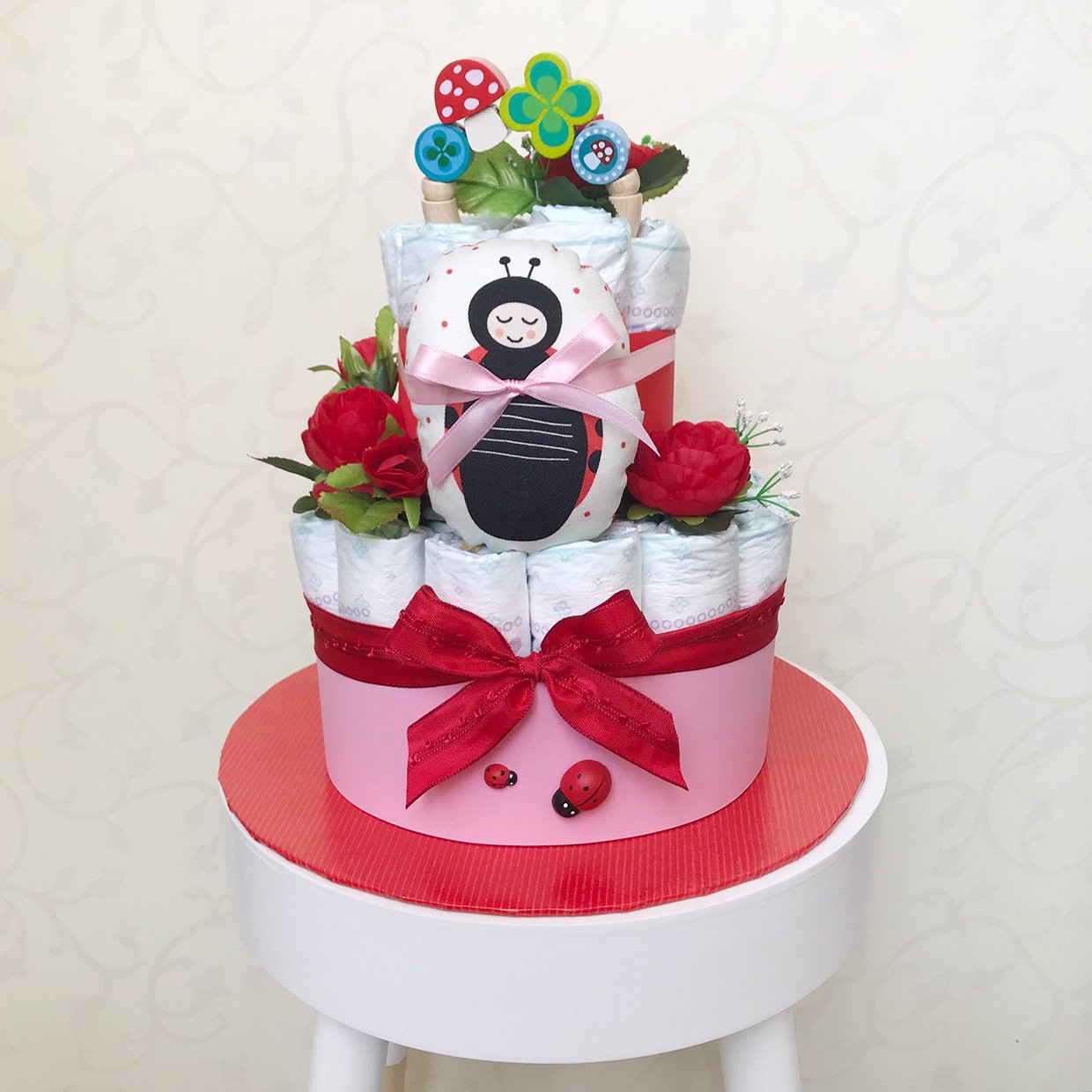 moments Windeltorte Glückskäfer in Rosa und Rot – Geschenk zur Geburt